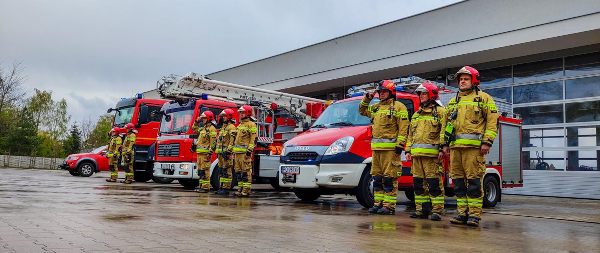 Na zdjęciu strażacy JRG Śrem na tle samochodów podczas upamiętnienia śmierci policjanta