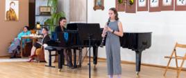 uczennica grająca na klarnecie a przy fortepianie nauczycielka