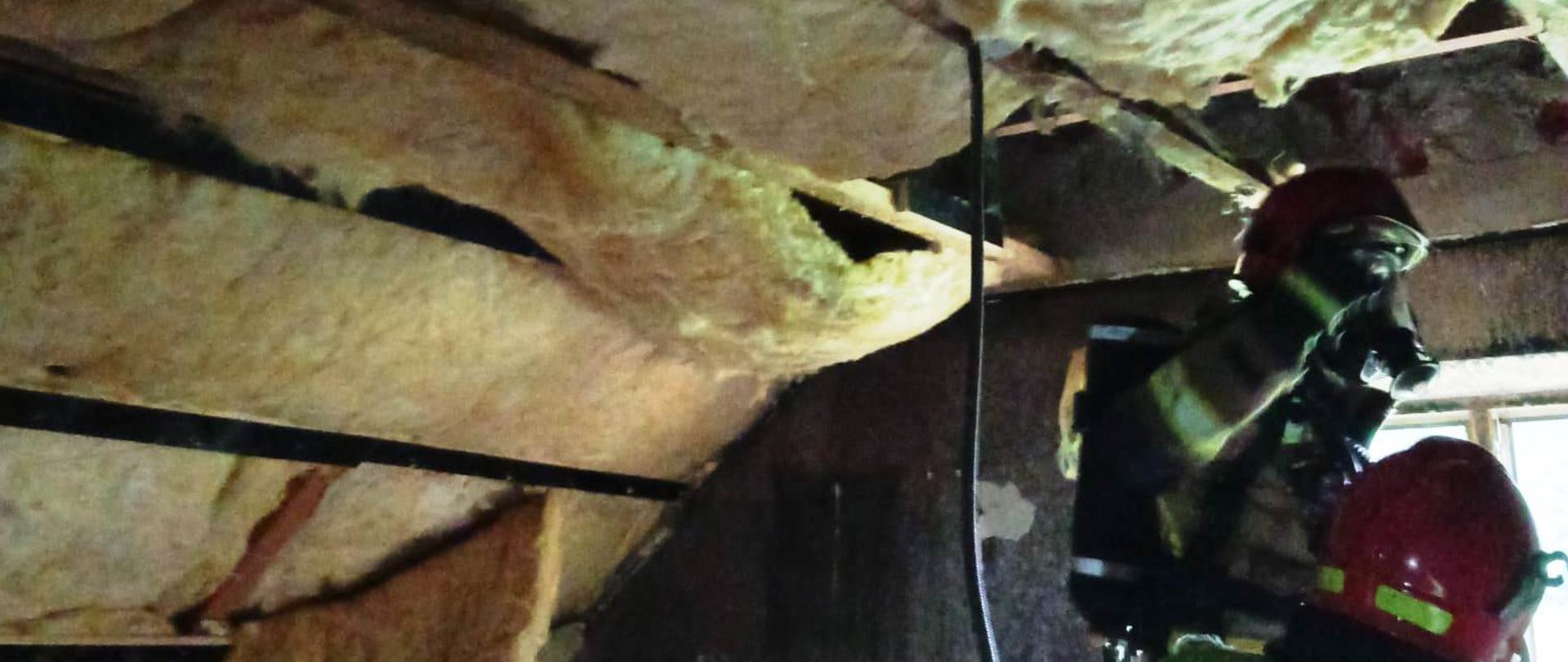 Strażacy prowadzą działania rozbiórkowe wewnątrz budynku.