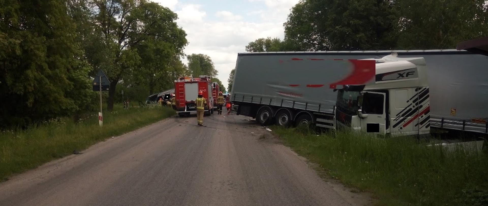 Zdjęcie przedstawia akcję ratowniczą wypadku drogowego na którym widać samochód ciężarowy w przydrożnym rowie 