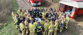 Zdjęcie przedstawia funkcjonariuszy PSP oraz druhów OSP omawiających ćwiczenia 