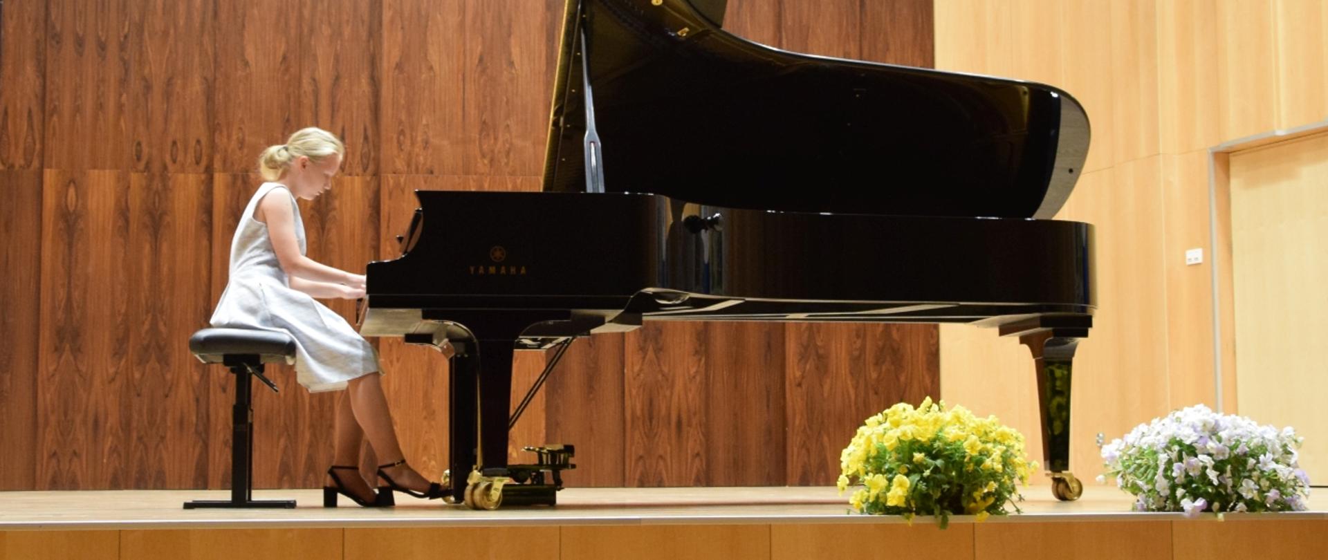 na scenie uczennica grająca na fortepianie