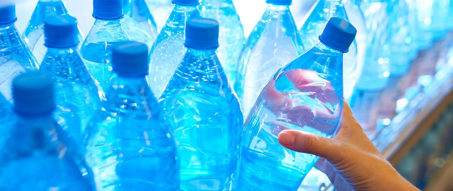 Dłoń bierze butelkę w dłoń 