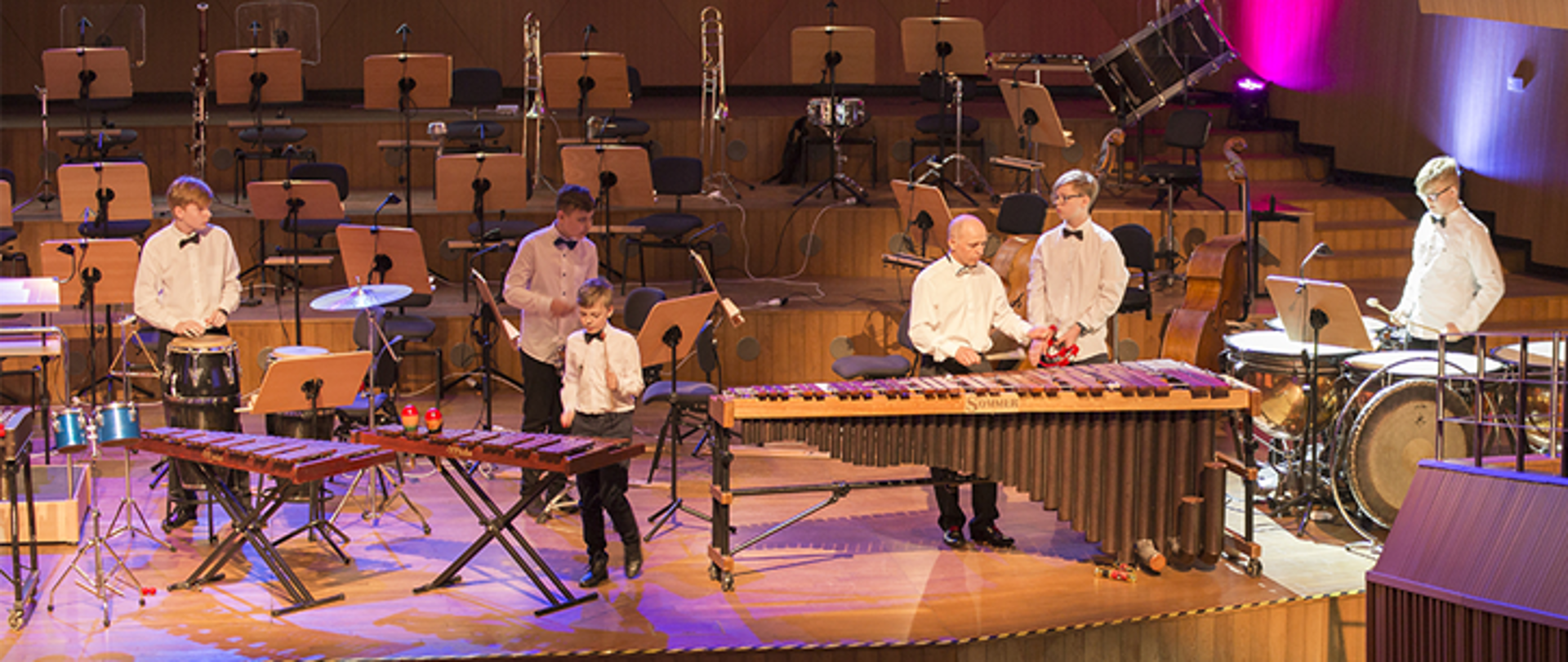 Scena koncertowa, uczniowie grają na instrumentach perkusyjnych.