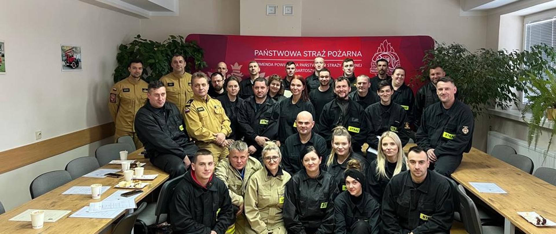 Uczestnicy szkolenia na wspólnym zdjęciu, w tle logo PSP Bartoszyce