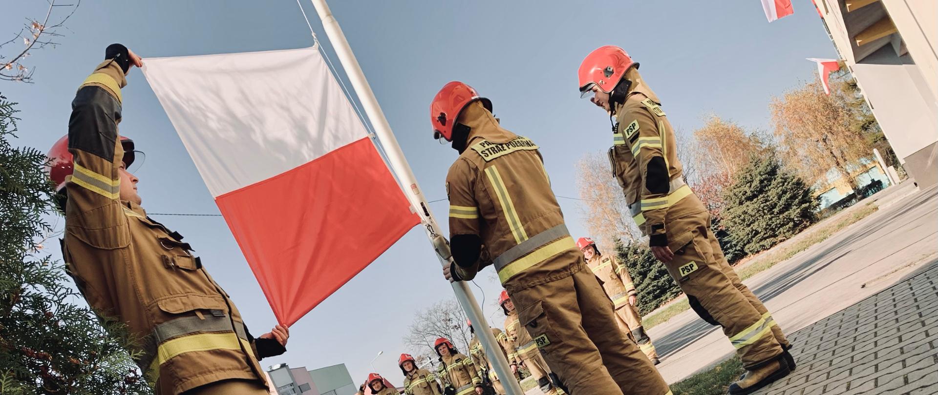 Zdjęcie przedstawia funkcjonariuszy JRG Jaworzno wywieszających flagę z okazji Narodowego Święta Niepodległości.