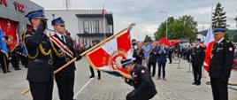 Komendant Powiatowy całuje sztandar KP PSP w Wadowicach. Po lewej stronie widzimy poczet sztandarowy, natomiast z prawej stoi Komendant Wojewódzki PSP.