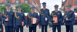 Na zdjęciu widnieje grupa strażaków, która została odznaczona w trakcie Wojewódzkich Obchodów Dnia Strażaka. 