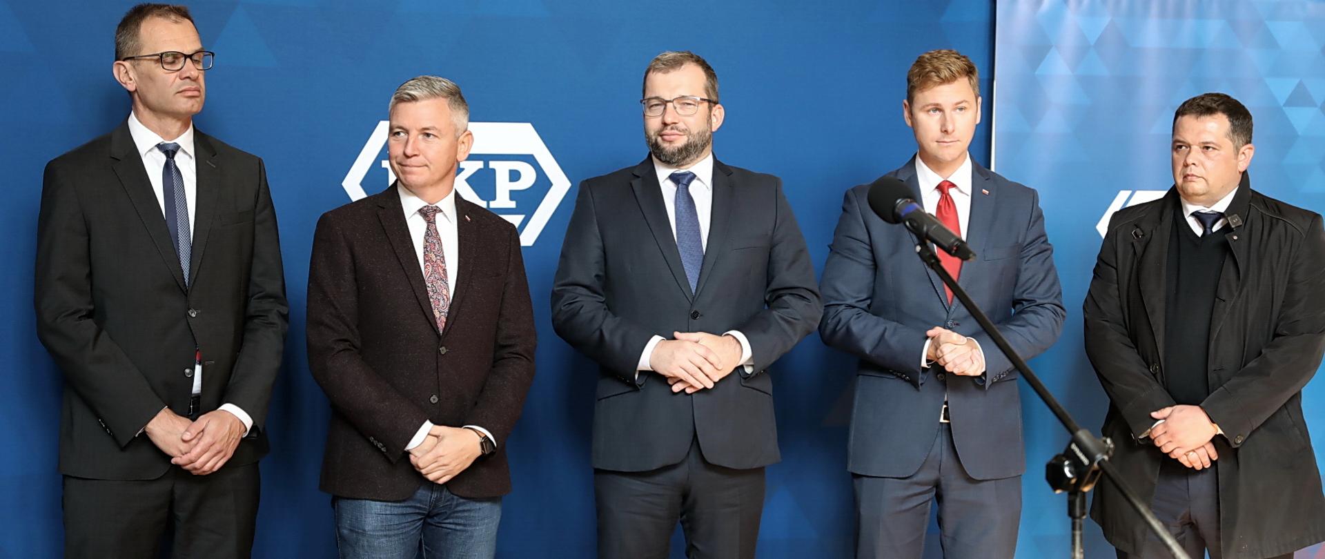 Pięć osób stoi obok siebie w jednym rzędzie. W środku stoi minister funduszy i polityki regionalnej Grzegorz Puda.