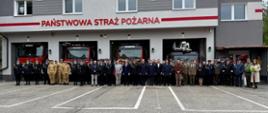 Na zdjęciu grupa strażaków oraz zaproszonych gości na tle remizy.