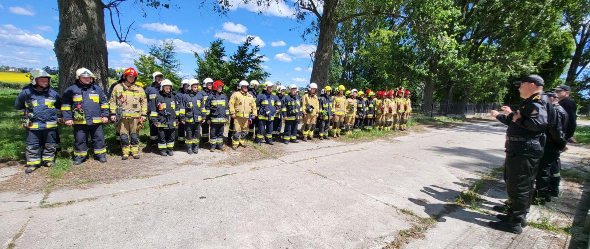 Zbiórka po warsztatach, strażacy ubrani w ubrania specjalne oraz dowództwo 