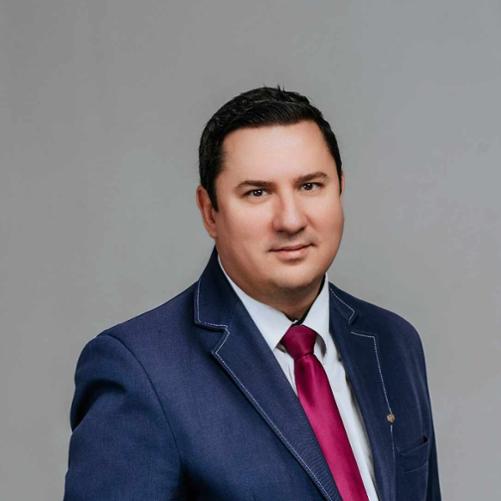 Zdjęcie przedstawia portret Lubuskiego Wojewódzkiego Inspektora Jakości Handlowej Artykułów Rolno-Spożywczych, Pana Adama Misiaszka. Pan Adam widnieje na zdjęciu ubrany w niebieską marynarkę i czerwony krawat. 