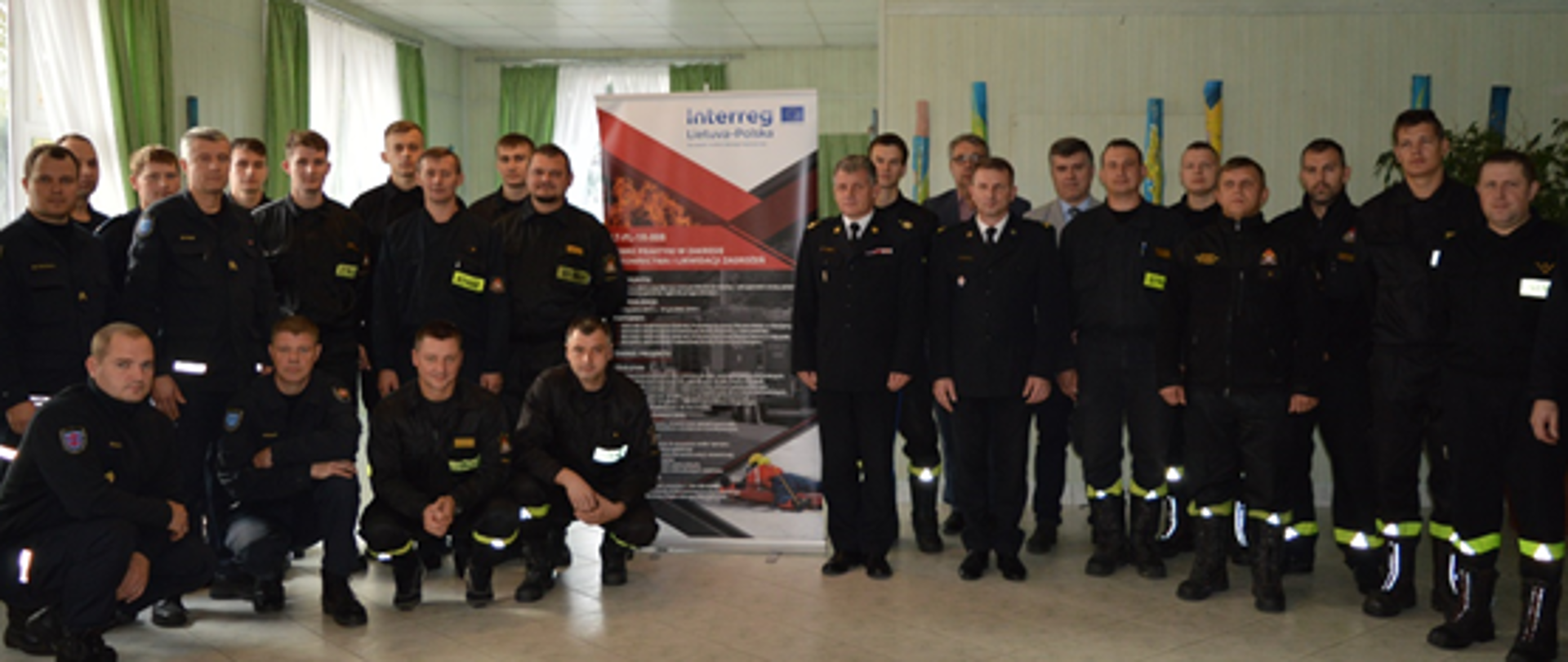 Strażacy w ubraniach koszarowych ustawieni rzędzie do zdjęcia 