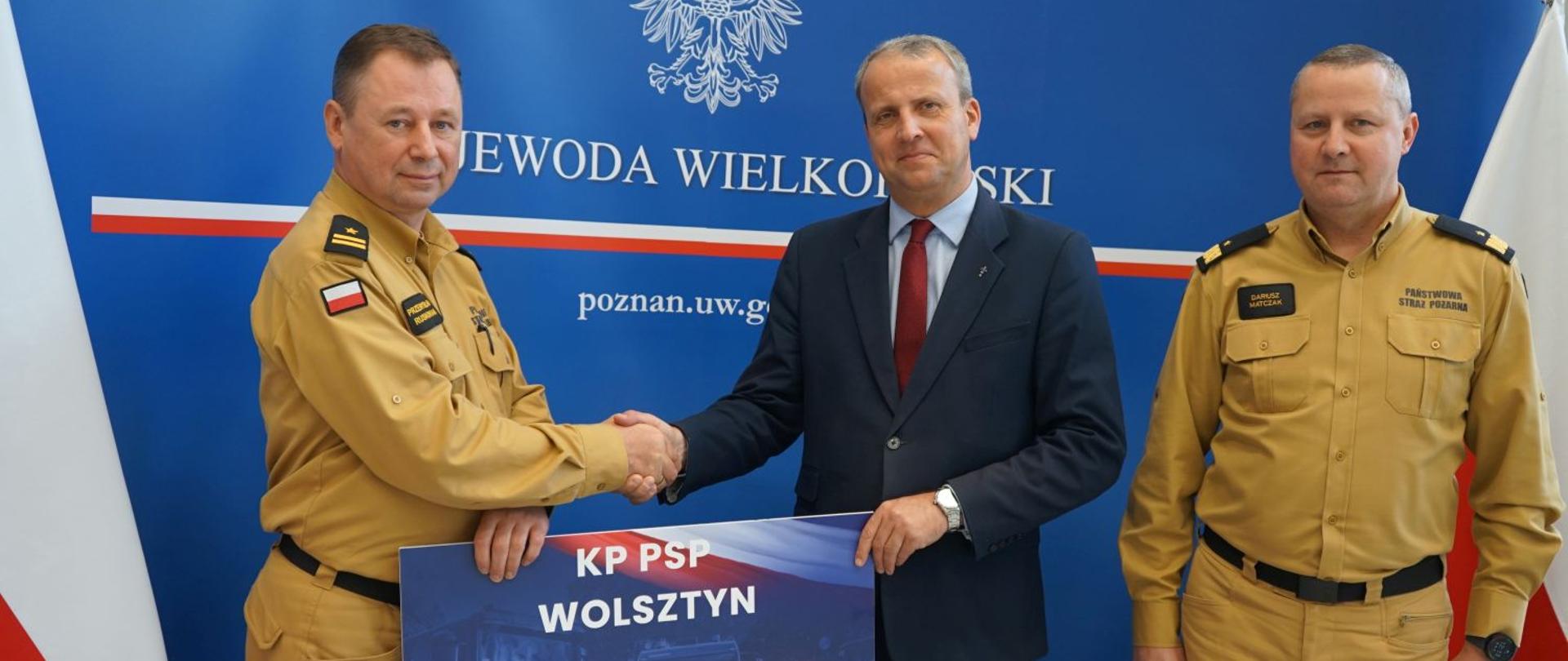 Wojewoda Wielkopolski oraz Wielkopolski Komendant Wojewódzki PSP wręczają promesę Komendanto Powiatowemu PSP w Wolsztynie.