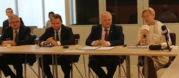 Cztery osoby siedzą przy stole, wśród nich jest minister Zielińska, która w ręku trzyma mikrofon 
