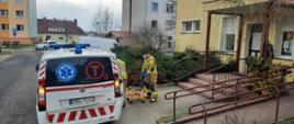 Pomoc strażaków przy transporcie osoby starszej do punktu szczepień