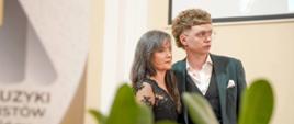 Zdjęcie Pani Dyrektor PSM I st. wraz z wykonawcą na scenie sali koncertowej podczas Koncertu "Muzyka dodaje skrzydeł" 04.04.2025 r.