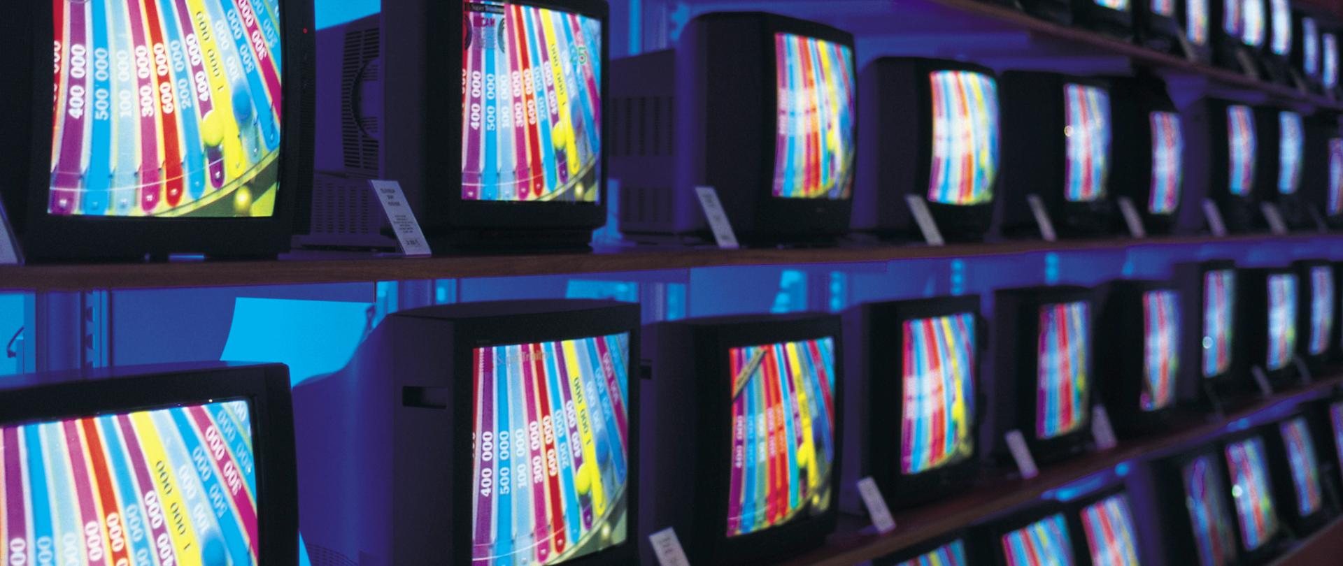 Na zdjęciu widzimy kilka telewizorów stojących obok siebie. 