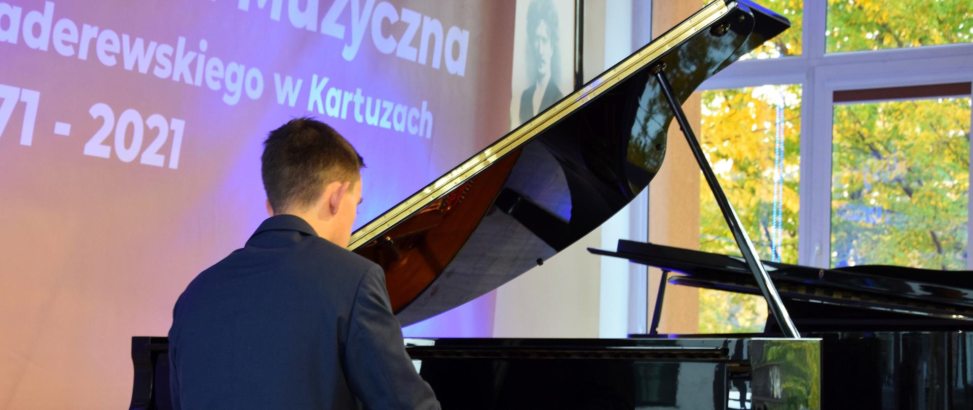 na zdjęciu widoczna jest sylwetka pianisty grającego na fortepianie