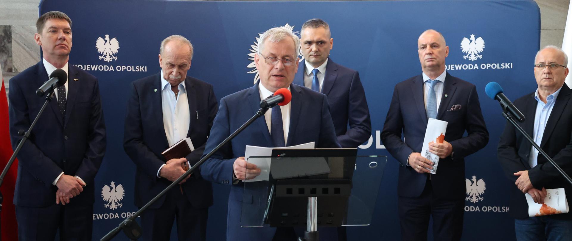 Wojewoda opolski na ściance UW, drugim 5 osób. 