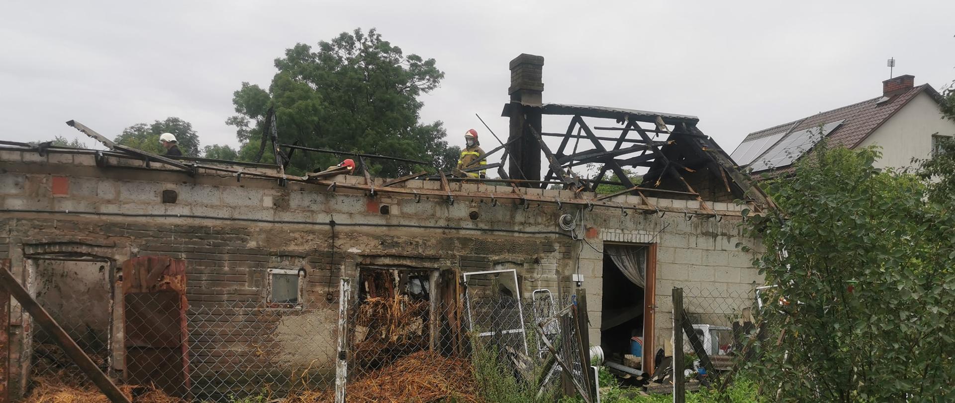 zgliszcza dachu budynku obory widziane z drogi