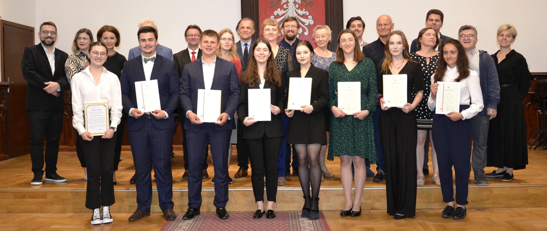 tegoroczni dyplomanci II stopnia zgromadzeni wraz ze swoimi nauczycielami na scenie Państwowej Szkoły Muzycznej w Mielcu