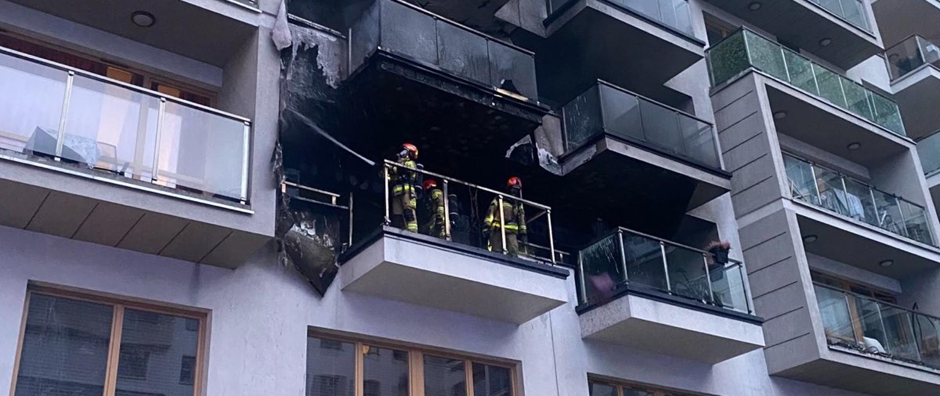 Strażacy na spalonym balkonie