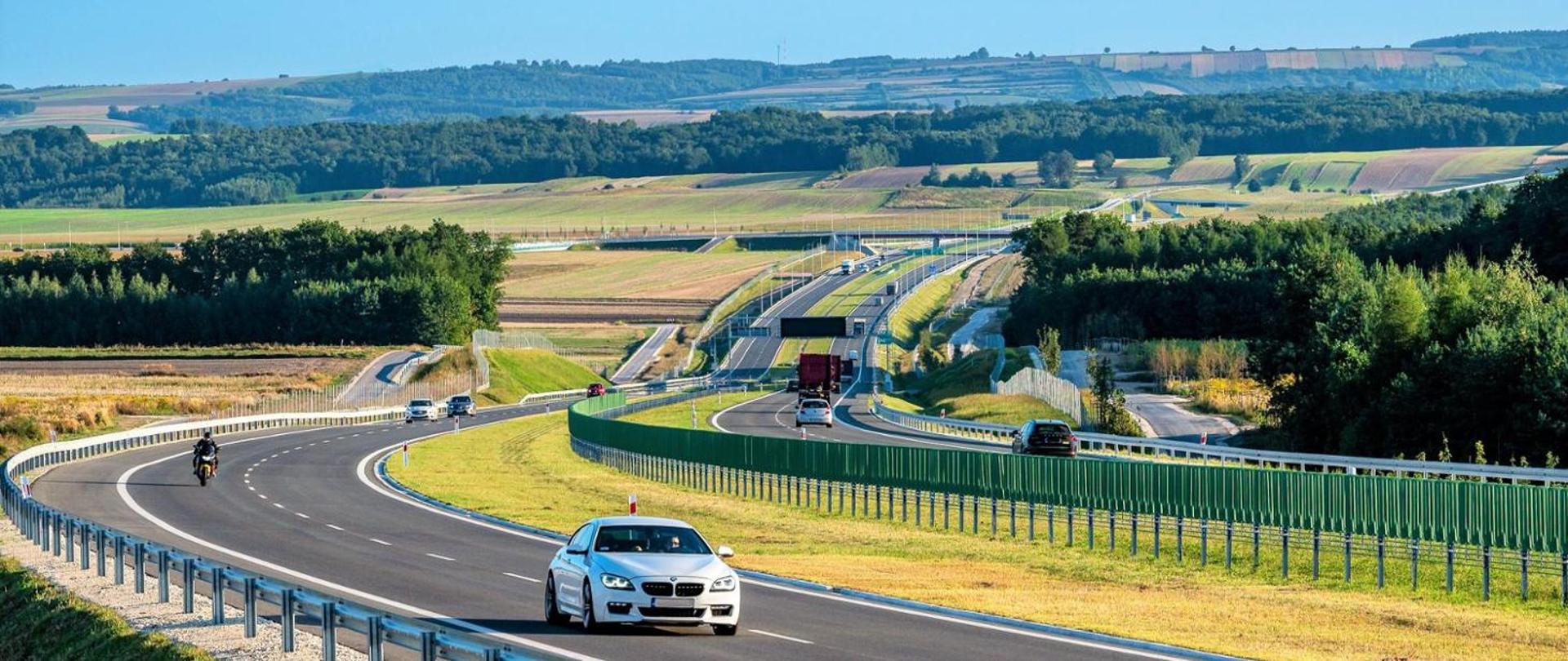Droga szybkiego ruchu, w tle wzgórza i zalesione tereny