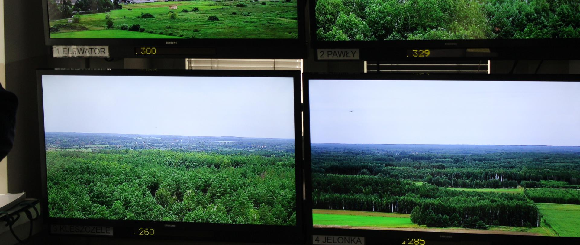 Cztery monitory, z których z wysokości prowadzony jest monitoring na tereny leśne. 