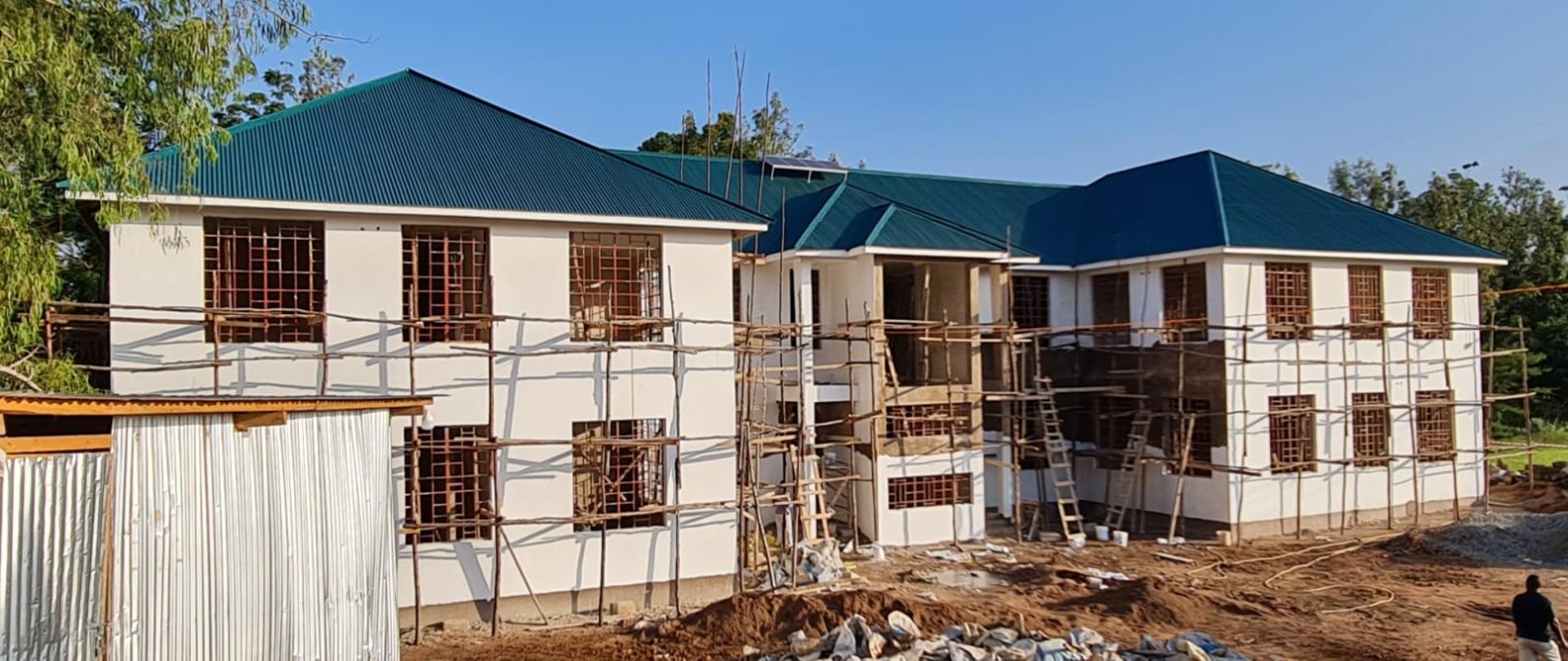 Otynkowany budynek z zielonym dachem.