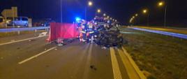 Tragiczny wypadek na S5. Rozbity samochód na pasie drogi. Obok stoją strażacy i ratownicy medyczni. w Tle samochody strażackie i karetka.