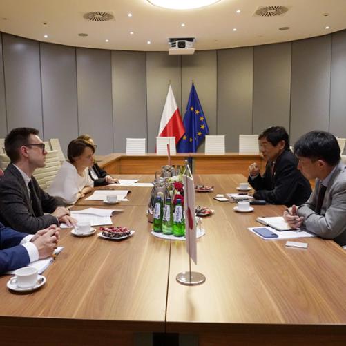 Wiceminister Jadwiga Emilewicz (po lewej stronie) wraz z pracownikami siedzi przy stole i rozmawia z przedstawicielami z Japonii