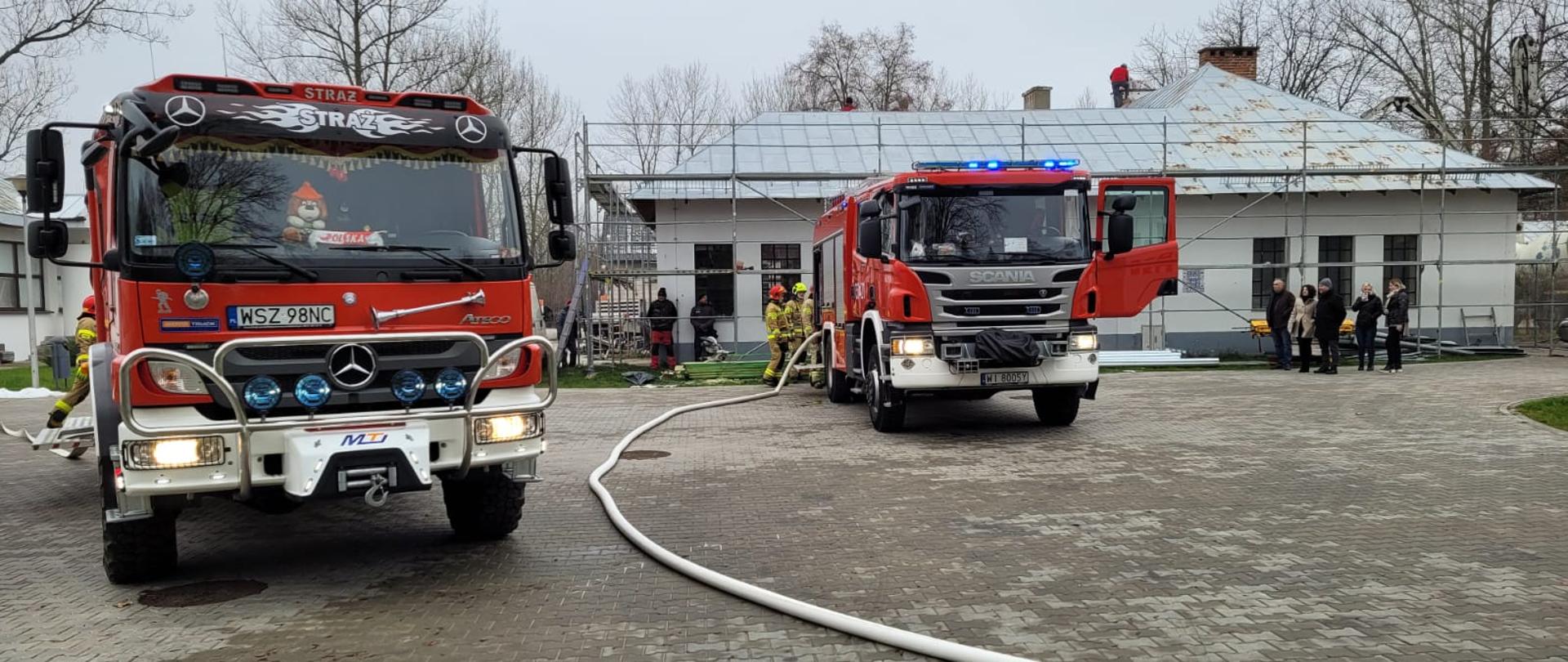 Fotografia przedstawiająca strażaków z JRG Szydłowiec oraz OSP Orońsko podczas ewakuacji ludzi podczas prowadzonych ćwiczeń na obiekcie.