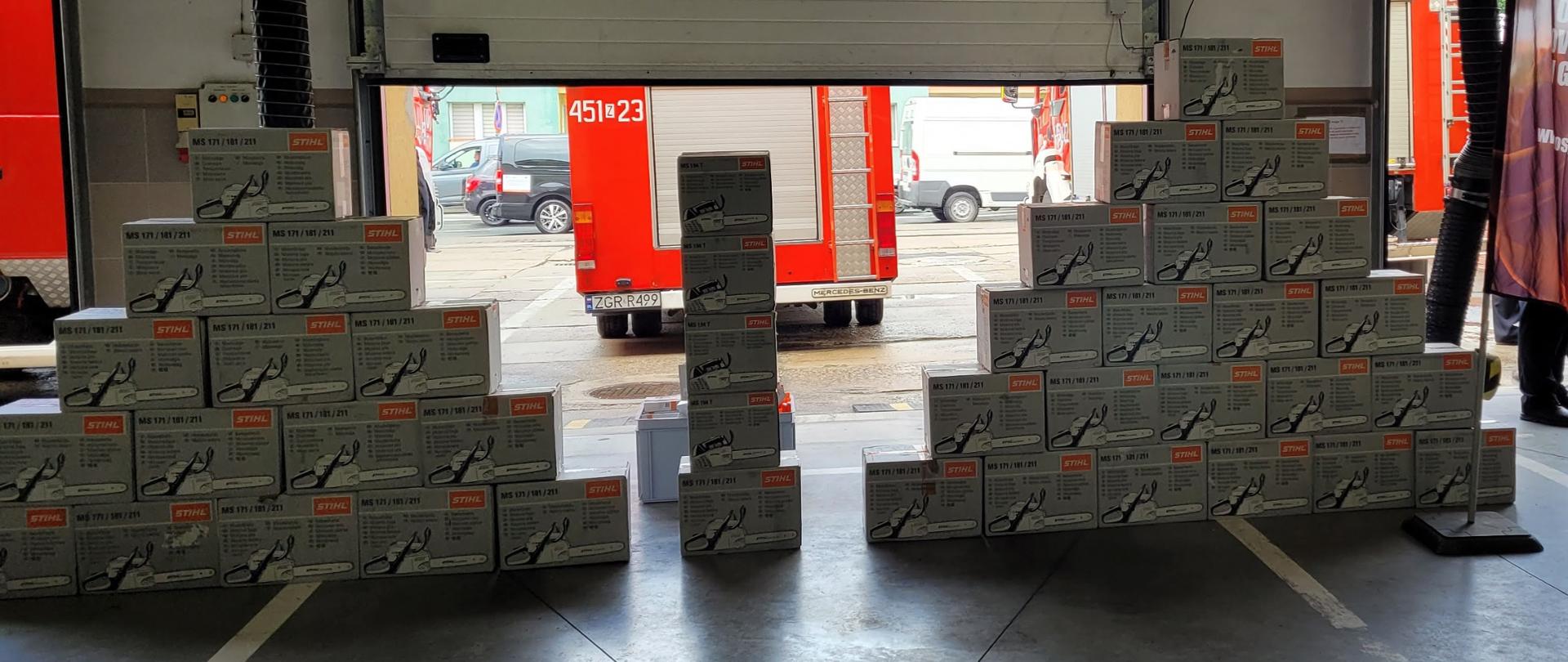 Na zdjęciu 41 pilarek spalinowych, w tle samochód pożarniczy