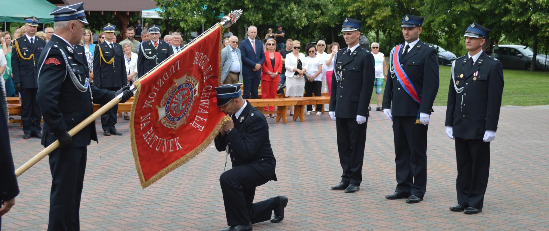 Na zdjęciu Prezes OSP Krojczyn całuje płat nowego sztandaru podczas przekazania, do wręczenia sztandaru występuje poczet sztandarowy