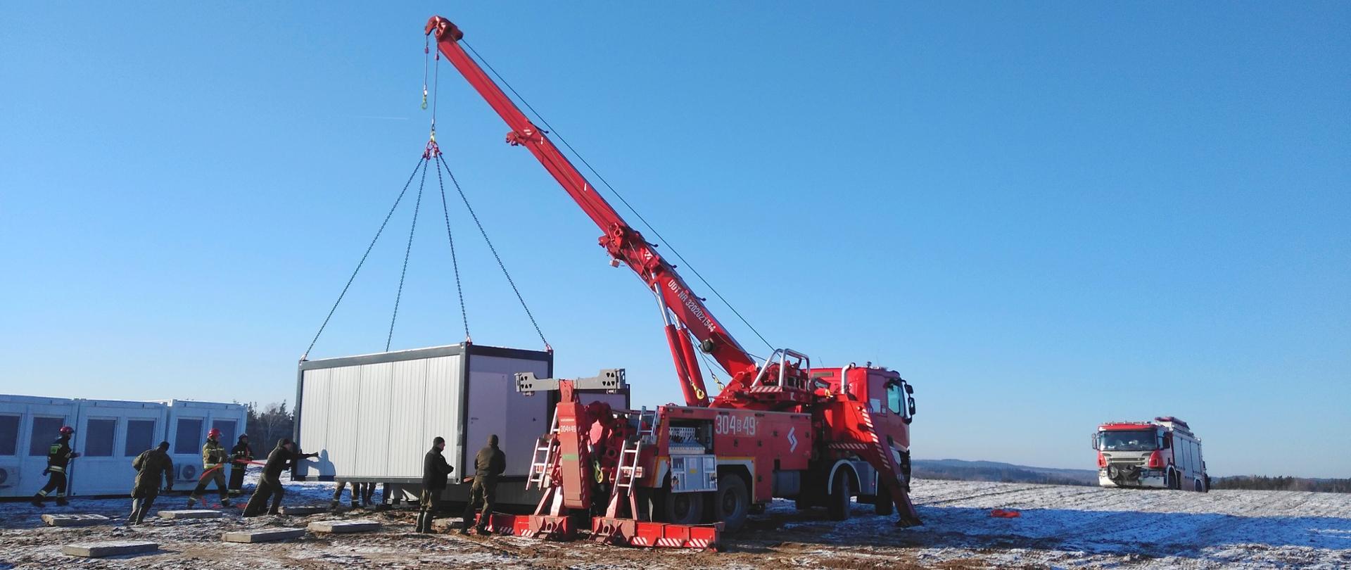 Zdjęcie przedstawiające prace przy rozładunku kontenerów mieszkalnych dla Wojska Polskiego