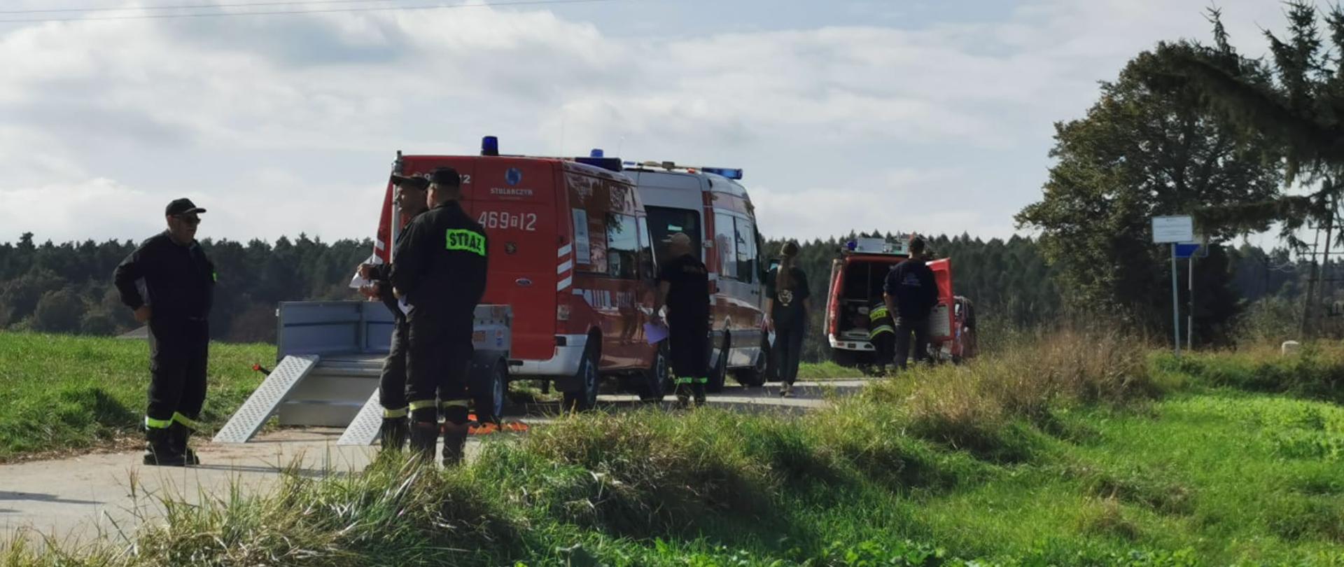 Strażacy ratownicy przygotowujący się do poszukiwań. Samochody pożarnicze przebywające w rejonie koncentracji.