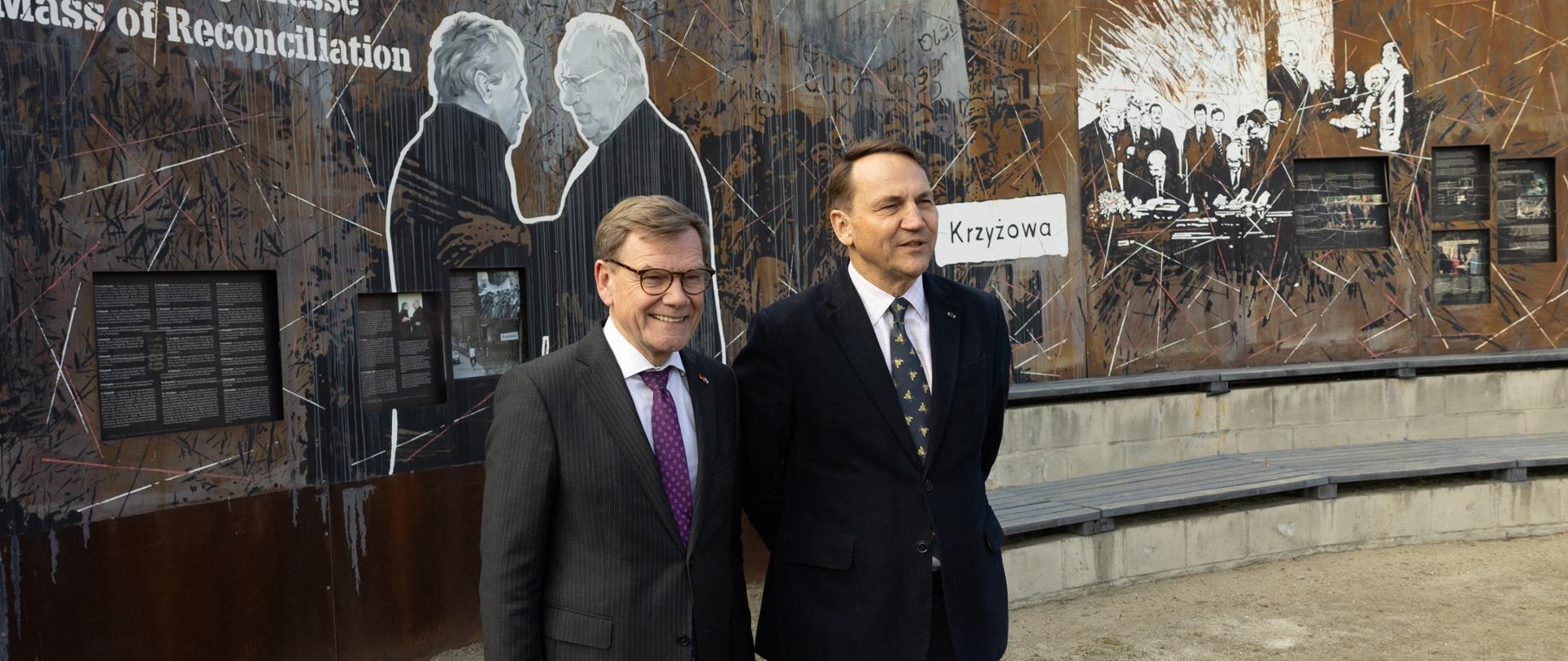 Na zdjęciu dwóch ministrów spraw zagranicznych w garniturach. W tle wystawa.