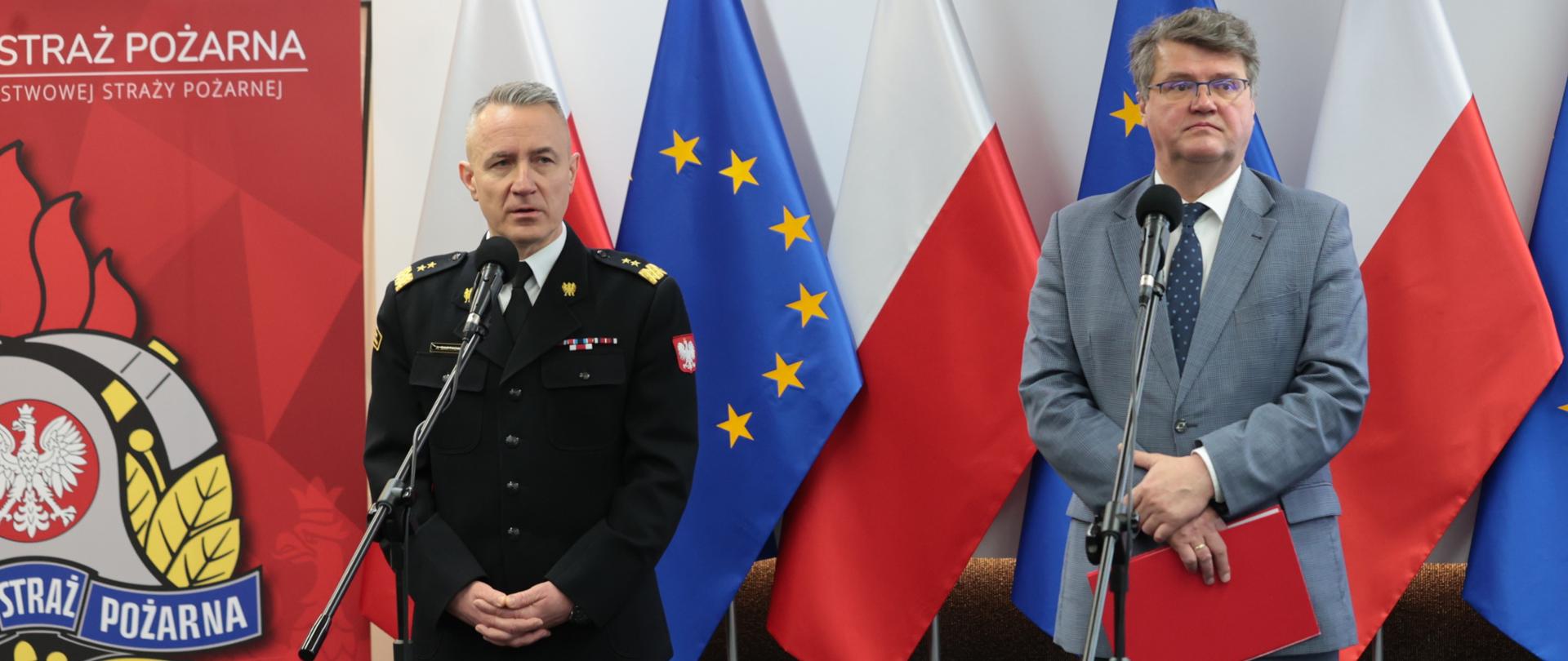 Minister i Komendant Główny PSP na tle flag Polski i UE.