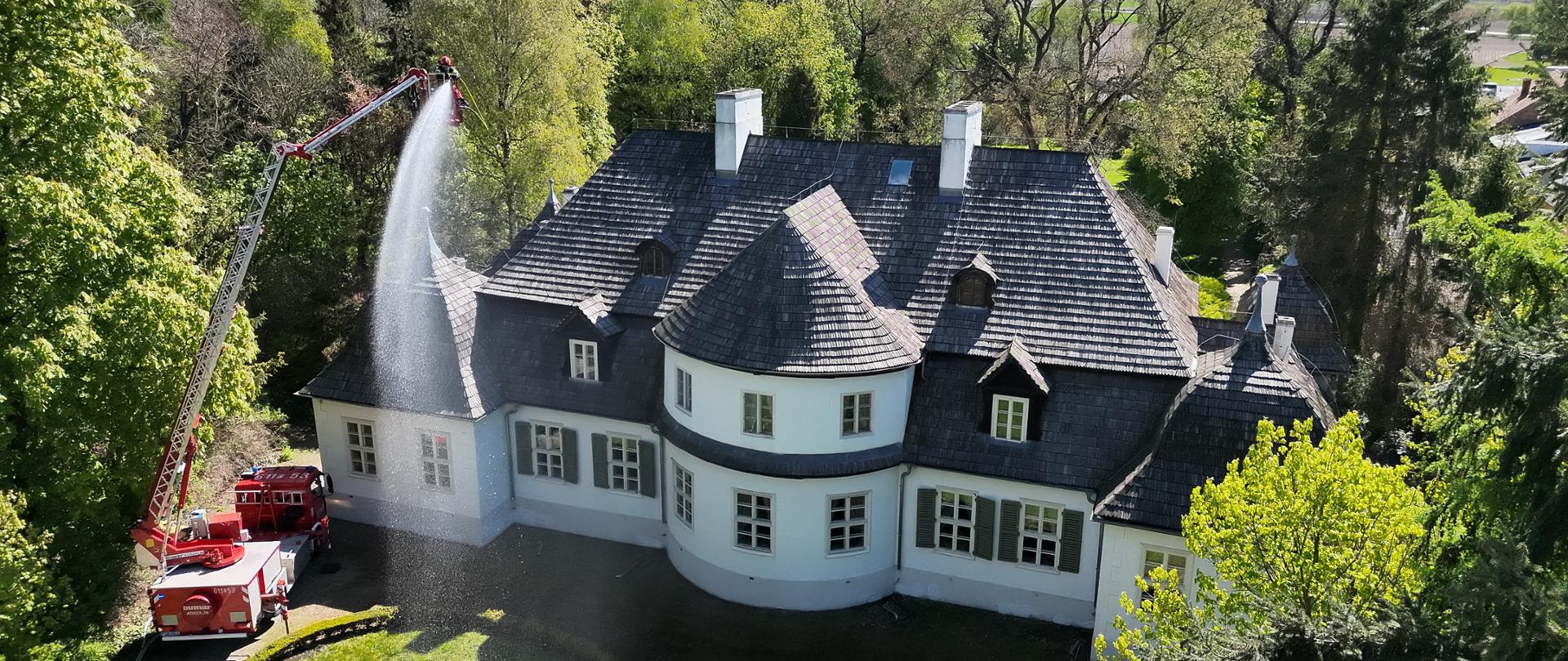 Podawanie prądu gaśniczego z wysięgnika hydraulicznego SHD 25 na palący się budynek muzeum