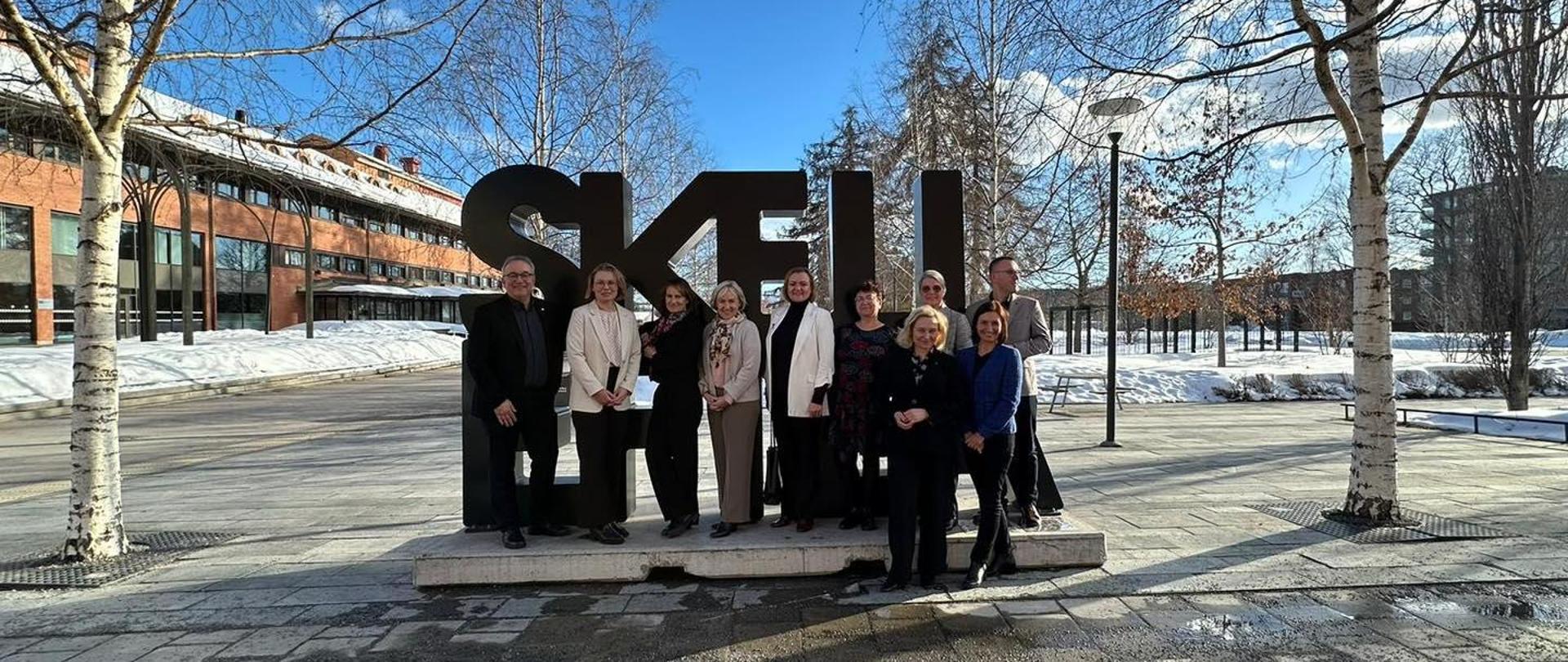 Grupa osób stoi na placu przed dużym napisem Skellefteå