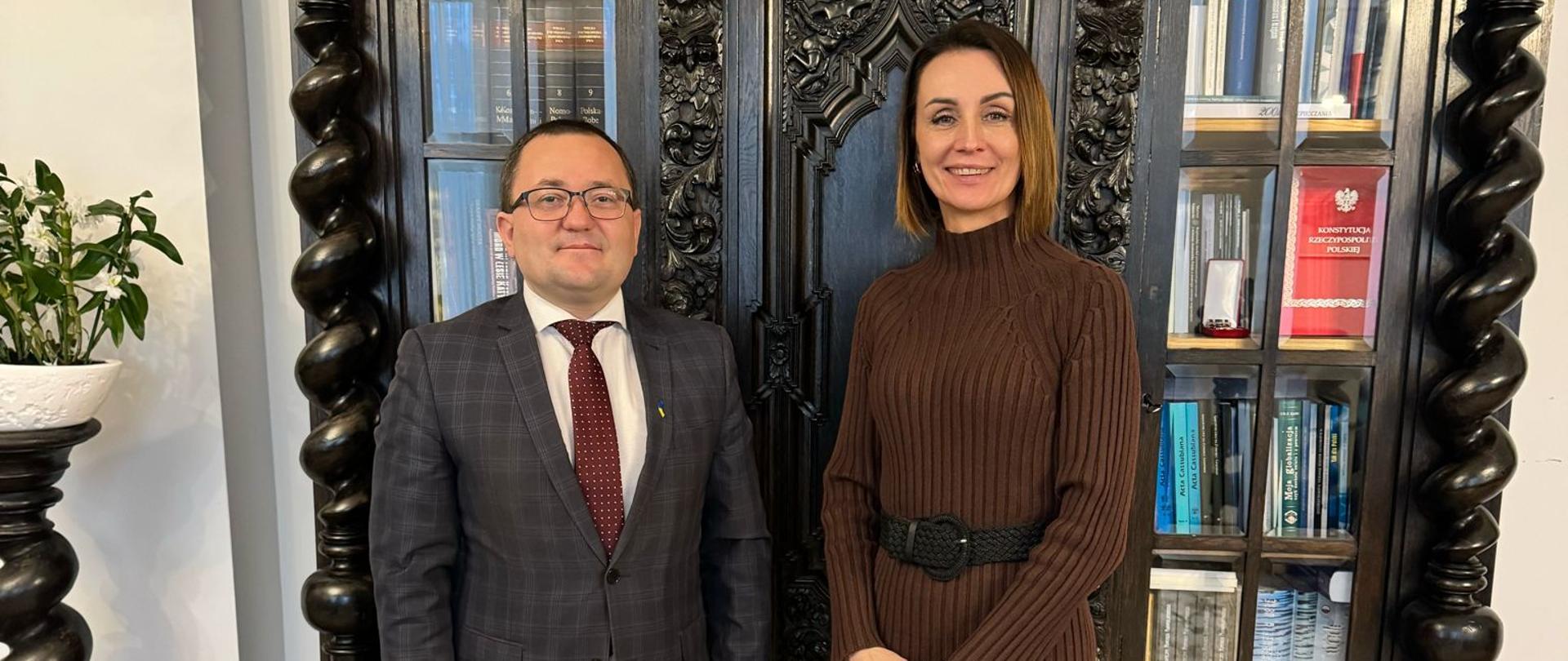 na tle zabytkowej biblioteczki stoi kobieta (wojewoda pomorska) i mężczyzna (konsul Ukrainy), gabinet wojewody