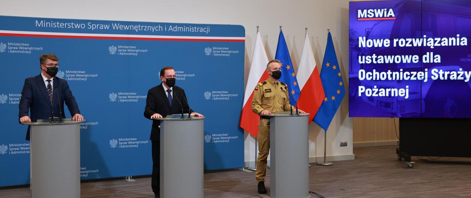 Fotografia przedstawiająca konferencje na której widać ministra MSWiA, sekretarza stanu w MSWiA wraz z Komendantem Głównym Państwowej Straży Pożarnej omawiających projekt ustawy o Ochotniczej Straży Pożarnej.