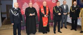 Zdjęcie przedstawia ks. prałata Mieczysława Rusina kapelana strażaków Archidiecezji Przemyskiej i ks. dr Mariana Hofmana kapelana strażaków powiatu przemyskiego oraz komendanta miejskiego PSP wraz zastępcą i zaproszonymi gośćmi podczas modlitwy wigilijnej