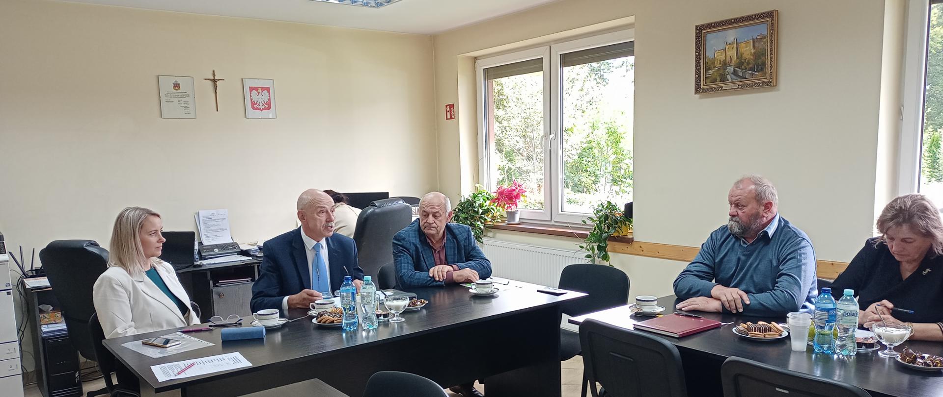 Grupa osób przy stołach obrad