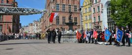 Poczet flagowy salutuje podczas podnoszenia flagi państwowej