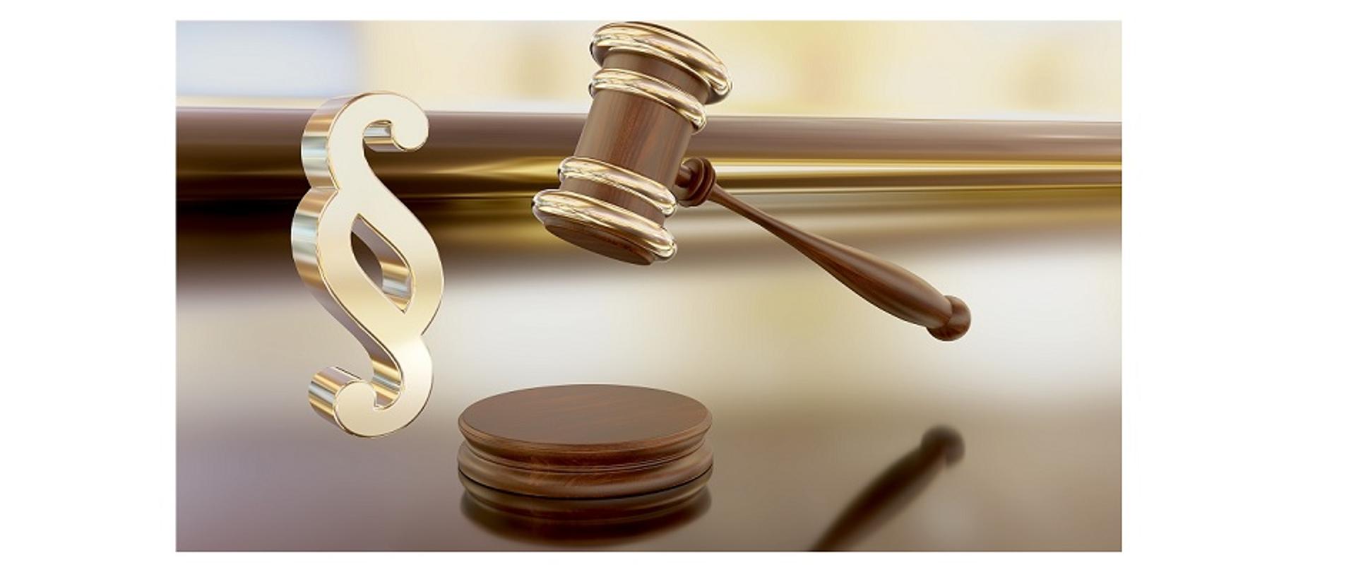 zdjęcie przedstawiające młotek sędziowski ze złotym paragrafem