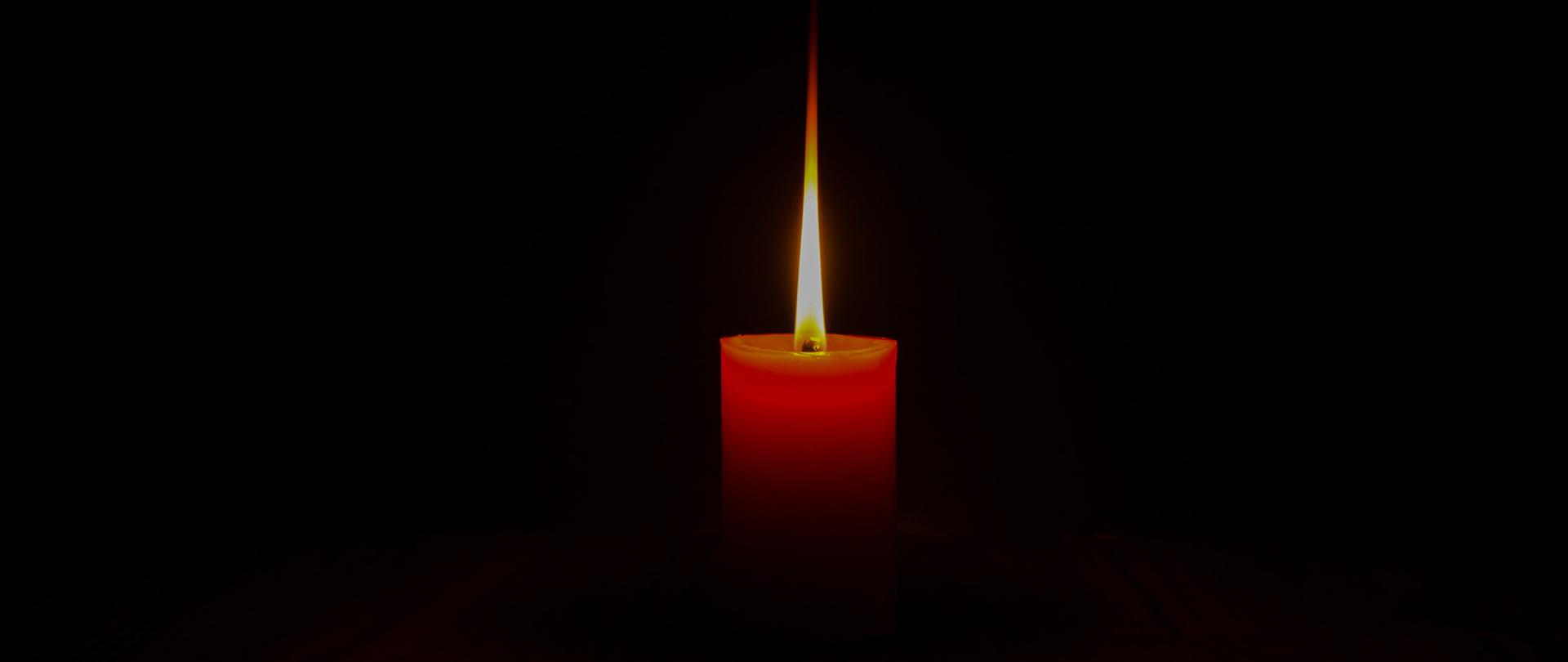 One candle light reflecting the shadow Black background