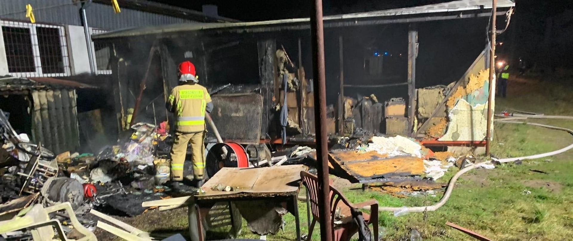 strażak w hełmie przy spalonej wiacie