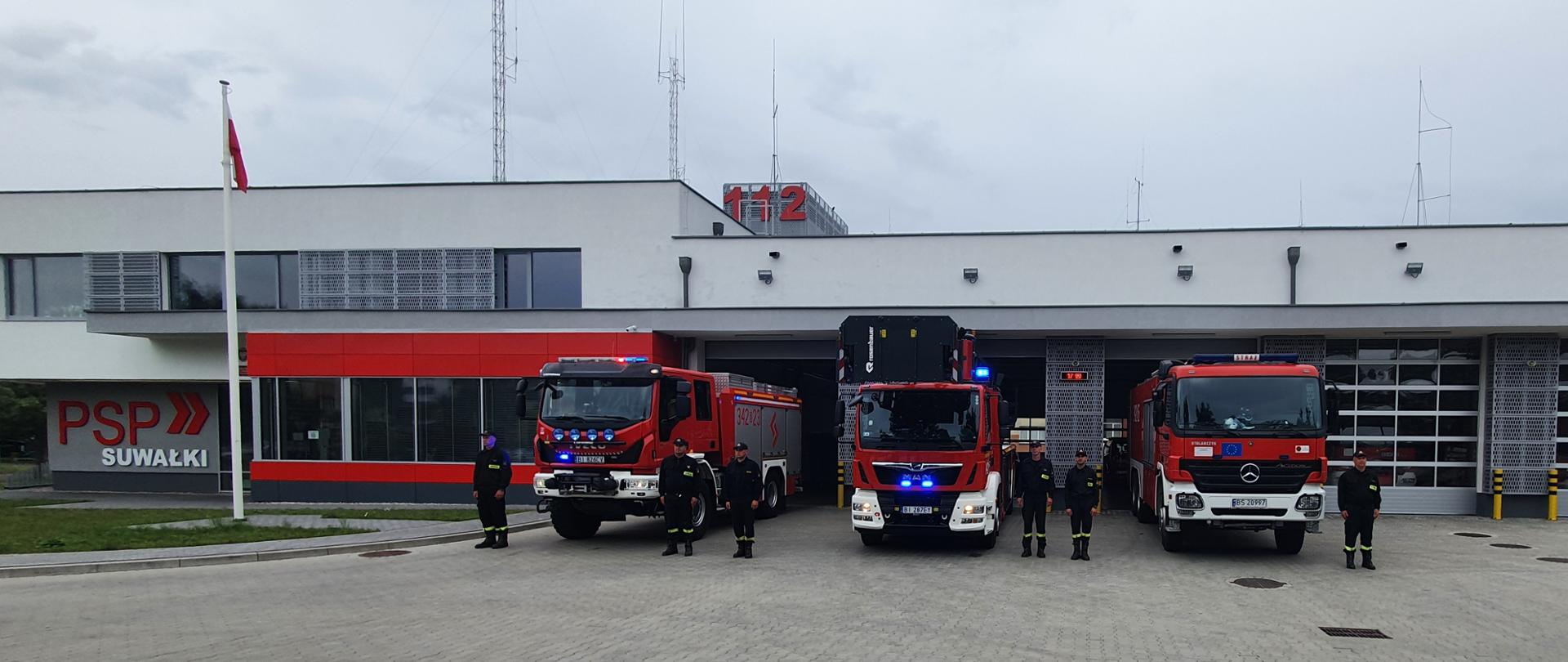 Hołd dla Powstania Warszawskiego, na zdjęciu widać wozy strażackie przed garażami i strażaków stojących na baczność